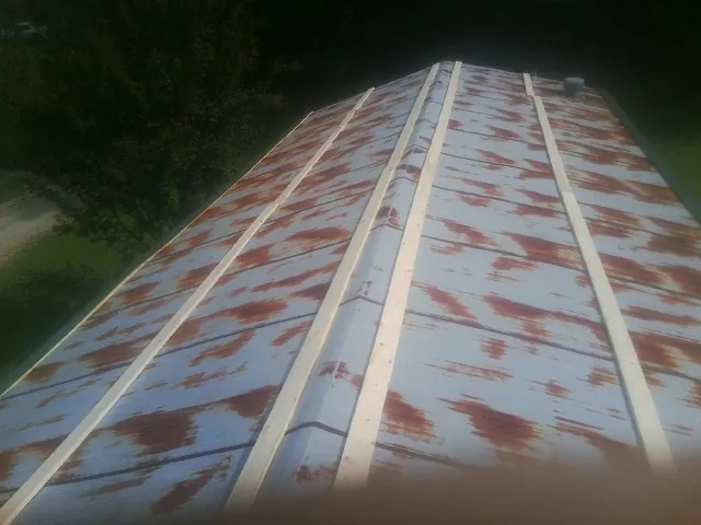 Rusted metal roof panels with new wood purlins before replacement — Storm Damage Roof Repair in Garrett Park by Roofing Brothers