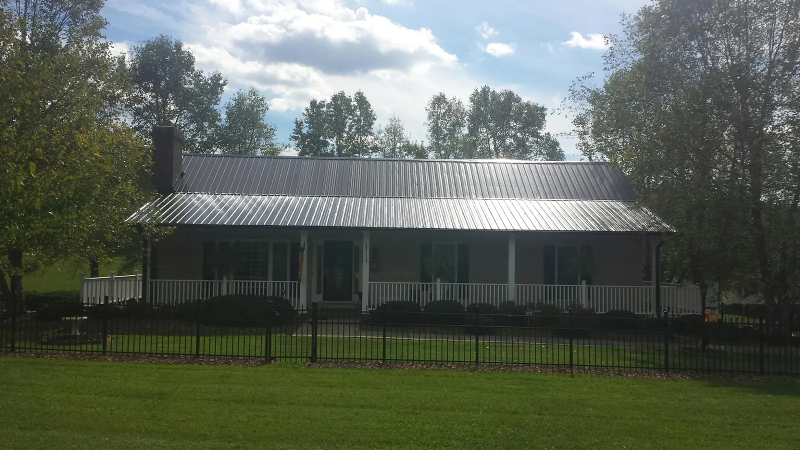 Gray metal roof on a brick ranch with a full width front porch — Gutter Guard Installation work by our crew in Garrett Park