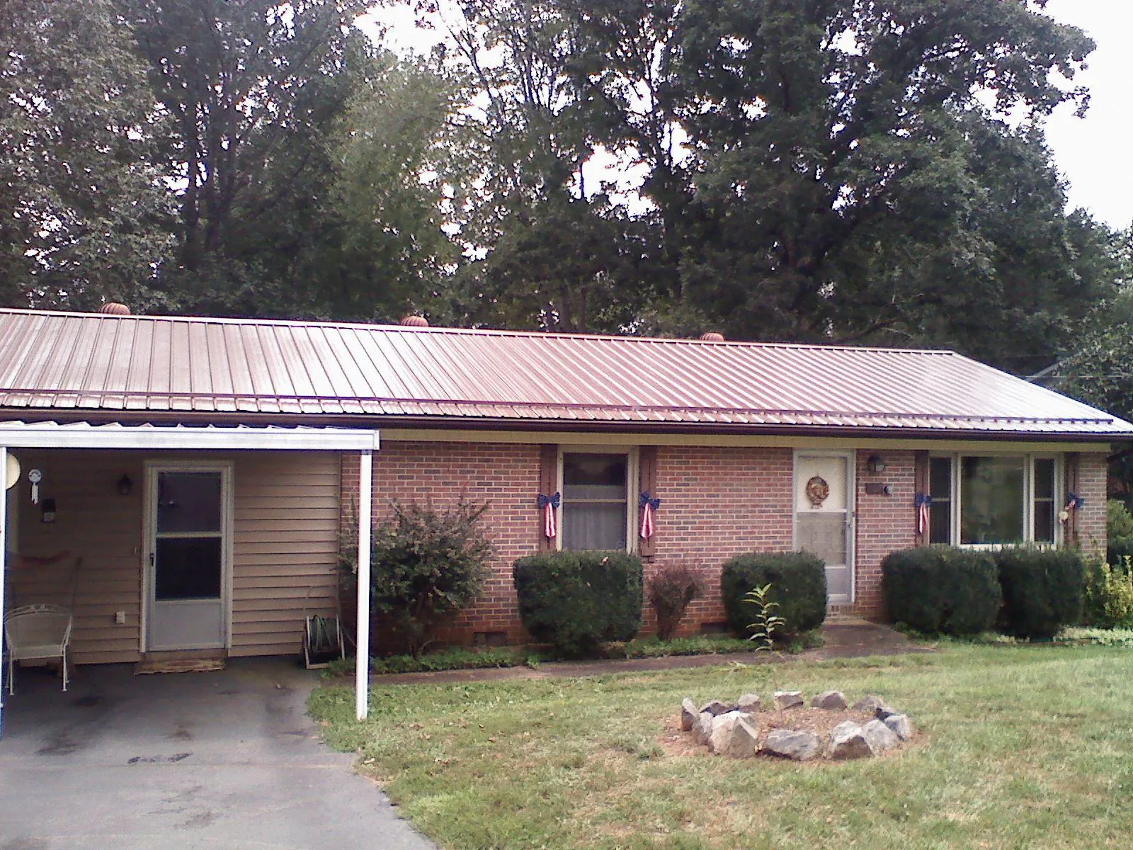 Bronze metal roof and carport on a brick ranch home — Roof Repair work by our crew in Garrett Park